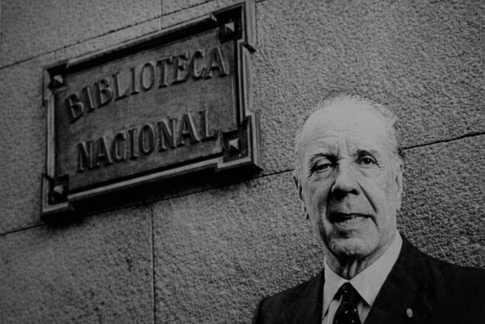 Jorge Luis Borges, escritor argentino y director de la Biblioteca Nacional, retratado frente a la institución que marcó buena parte de su vida intelectual. Dijo alguna vez que, en la vida de un escritor, la parte menos interesante, más deleznable o prescindible son sus opiniones políticas. · Foto: Colprensa + ChatGPT